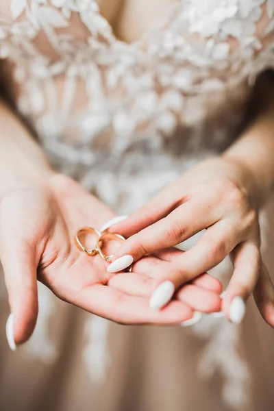 エレガントな白いドレスの美しい豪華な花嫁は手で結婚指輪を保持しています — ストック写真