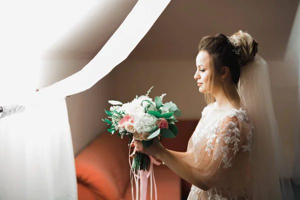 Bela noiva vestindo vestido de noiva de moda com penas com deleite de luxo maquiagem e penteado, estúdio sessão de fotos indoor — Fotografia de Stock