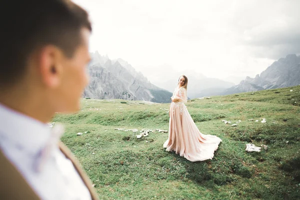 Hermosa novia hermosa posando para el novio y divertirse cerca de las montañas con una vista increíble, espacio para el texto, pareja de boda — Foto de Stock