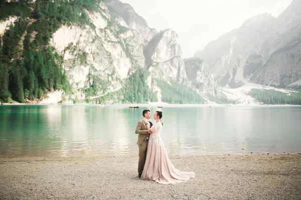 Hermosa pareja moderna cerca de un lago en las montañas hacer fotos de boda —  Fotos de Stock