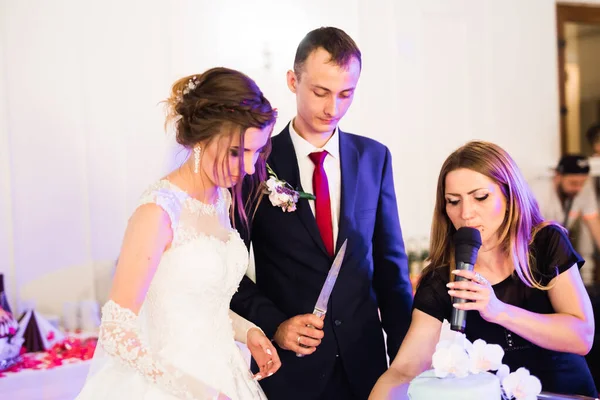 Brudgummen på bröllopet skär bröllopstårtan — Stockfoto