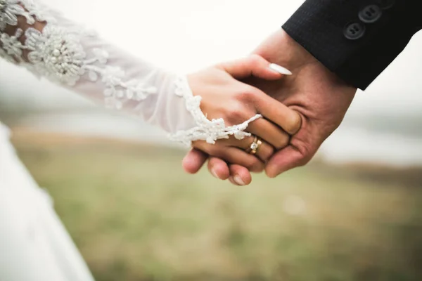 Свадебная пара держась за руки, жених и невеста вместе в день свадьбы — стоковое фото