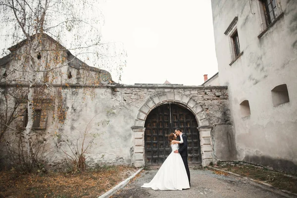 Bela noiva e noivo abraçando e beijando em seu dia de casamento ao ar livre — Fotografia de Stock