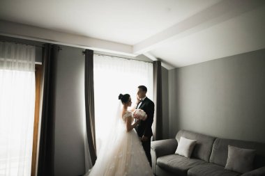 Doğadaki düğün çifti birbirine sarılıyor. Beyaz elbiseli güzel bir kız. Takım elbiseli adam