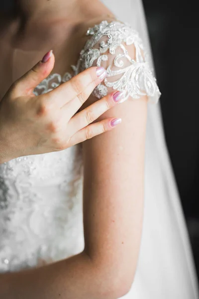 Hermosa novia con vestido de novia de moda con plumas con maquillaje de lujo deleite y peinado, estudio sesión de fotos interior — Foto de Stock