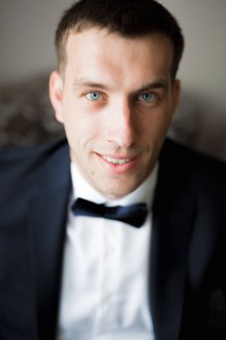 Güzel adam, damat poz veriyor ve düğüne hazırlanıyor.