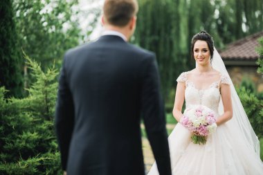 Göz kamaştırıcı mutlu çift birbirine yakın duruyor ve gözlerinin içine bakıyor.