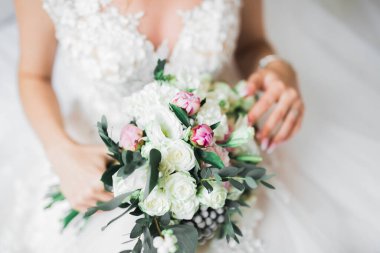 Gelin çiçekli büyük ve güzel bir düğün buketi tutuyor.