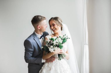 Doğadaki düğün çifti birbirine sarılıyor. Beyaz elbiseli güzel bir kız. Takım elbiseli adam