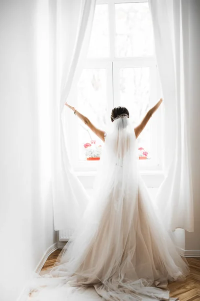 Prachtige bruid in badjas poseren en voor te bereiden op de bruiloft ceremonie gezicht in een kamer — Stockfoto