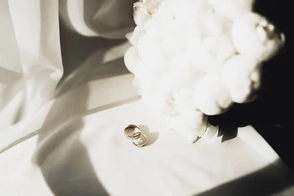Hermosa imagen tonificada con anillos de boda sobre el fondo de un ramo de flores — Foto de Stock