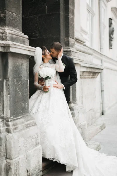 Schöne Braut und Bräutigam umarmen und küssen sich am Hochzeitstag im Freien — Stockfoto