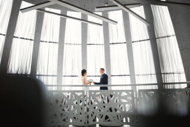 Göz kamaştırıcı mutlu çift birbirine yakın duruyor ve gözlerinin içine bakıyor.