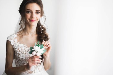 Lüks bir gelin, bir kız buketle poz veriyor ve gülümsüyor.