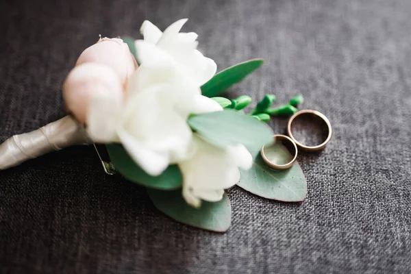 Jegygyűrűk és egy csokor rózsa és más virágok — Stock Fotó