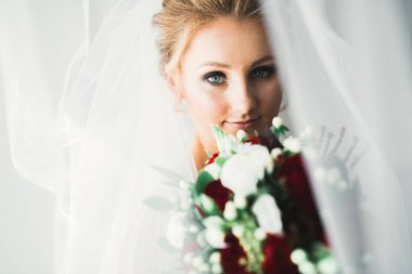 Tüylü, lüks makyaj, saç stili, stüdyo içi fotoğraf çekimi olan güzel bir gelin.