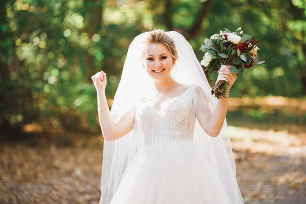 Pengantin wanita mewah, gadis yang berpose dan tersenyum dengan karangan bunga — Stok Foto