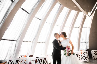 Güzel gelin ve damat düğün günlerinde kucaklaşıp öpüşürler.