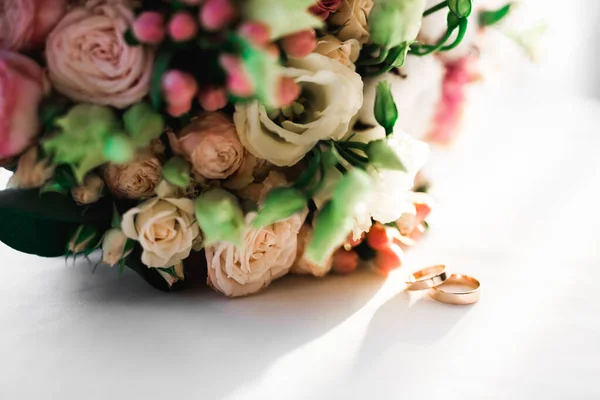 Красива тонована картина з обручками на тлі букета квітів — стокове фото