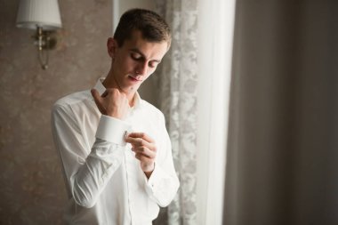 Güzel adam, damat poz veriyor ve düğüne hazırlanıyor.