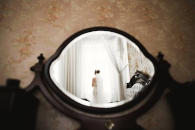 Beyaz elbiseli lüks gelin düğün törenine hazırlanırken poz veriyor.