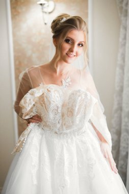 Beyaz elbiseli lüks gelin düğün törenine hazırlanırken poz veriyor.