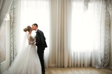 Güzel gelin ve damat düğün günlerinde kucaklaşıp öpüşürler.