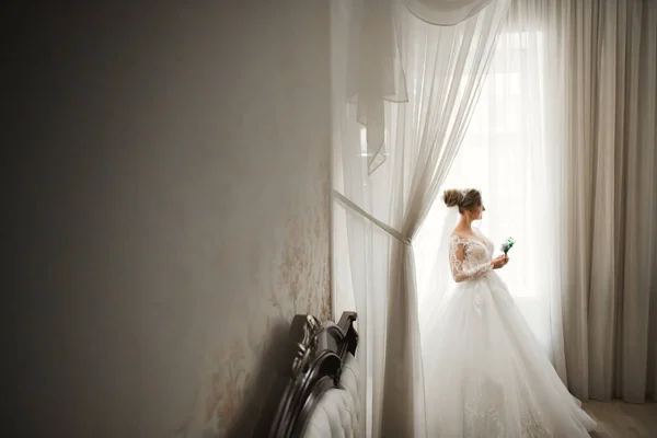 Novia de lujo en vestido blanco posando mientras se prepara para la ceremonia de boda — Foto de Stock