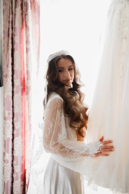Beyaz elbiseli lüks gelin düğün törenine hazırlanırken poz veriyor.