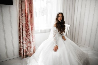 Beyaz elbiseli lüks gelin düğün törenine hazırlanırken poz veriyor.