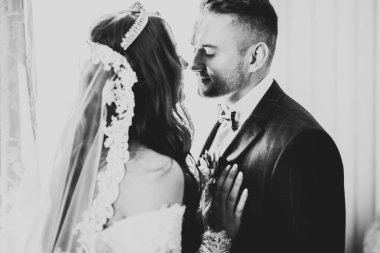 Göz kamaştırıcı mutlu çift birbirine yakın duruyor ve gözlerinin içine bakıyor.