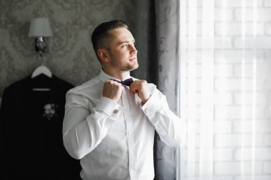 Güzel adam, damat poz veriyor ve düğüne hazırlanıyor.