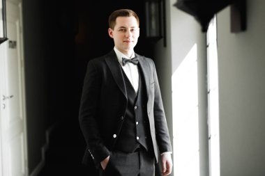 Güzel adam, damat poz veriyor ve düğüne hazırlanıyor.