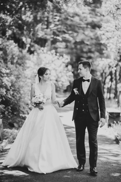 Pareja feliz boda caminando en un parque botánico — Foto de Stock