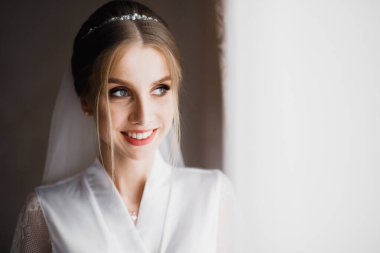 Tüylü, lüks makyaj, saç stili, stüdyo içi fotoğraf çekimi olan güzel bir gelin.