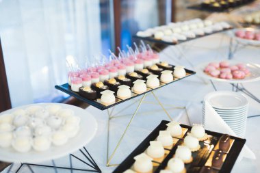 Çeşitli lezzetli tatlılar, yemek fikirleri ve kutlamalarla dolu bir büfe.