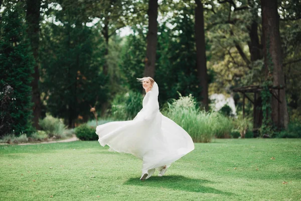 Parkta poz veren gelinlikli güzel, lüks bir gelin.