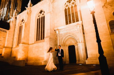 Harika bir tarihi binanın yakınında mükemmel bir elbiseyle dönen güzel bir gelin.