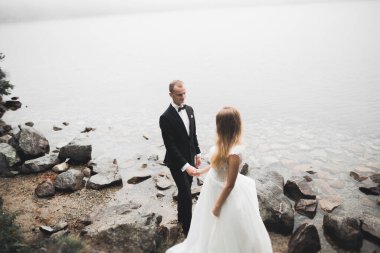 Öpüşen düğün çifti güzel manzarada kalıyor.