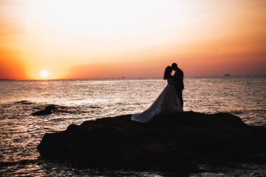 Güzel bir sahilde poz veren genç bir çiftin mutlu ve romantik sahnesi.