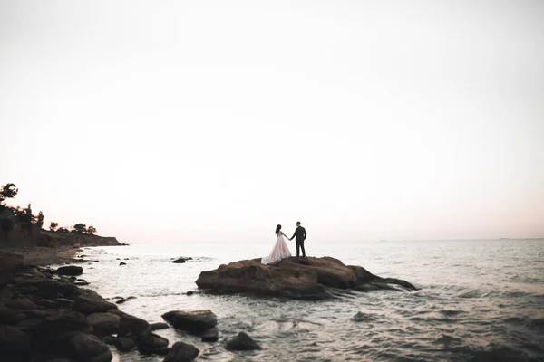 Elegante pareja de boda feliz elegante, novia, magnífico novio en el fondo del mar y el cielo — Foto de Stock