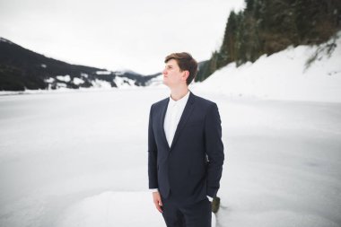 Güzel genç adam dağların arkasında kalıyor.