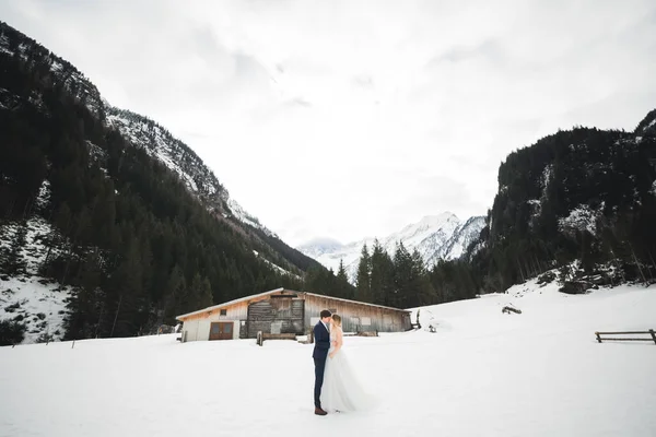 Młoda szczęśliwa para całuje, krajobraz gór w śniegu na tle — Zdjęcie stockowe
