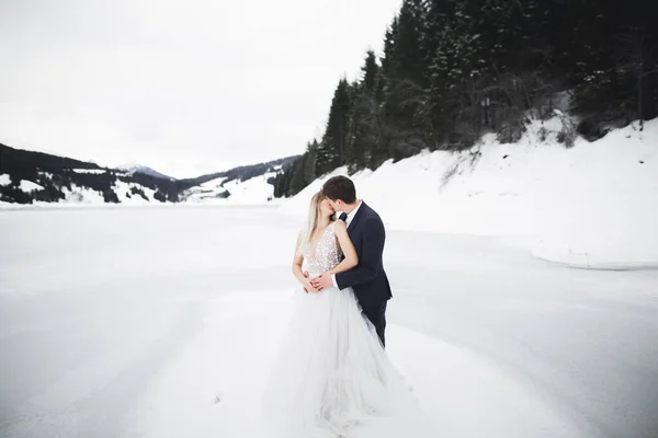 Jovem casal feliz beijando, montanhas paisagem na neve no fundo — Fotografia de Stock
