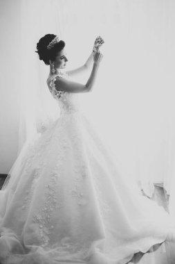 Çekici gelinin portresi, uzun saçlı, büyük buketli poz veren.