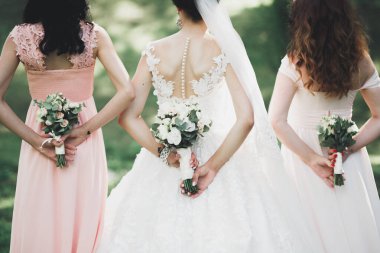 Gelin çiçekli büyük ve güzel bir düğün buketi tutuyor.