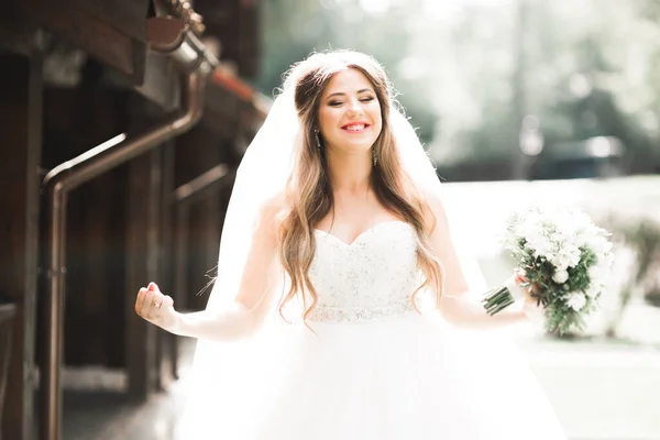 Hermosa novia posando en vestido de novia al aire libre — Foto de Stock