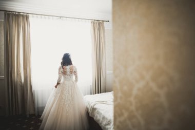 Beyaz elbiseli lüks gelin düğün törenine hazırlanırken poz veriyor.