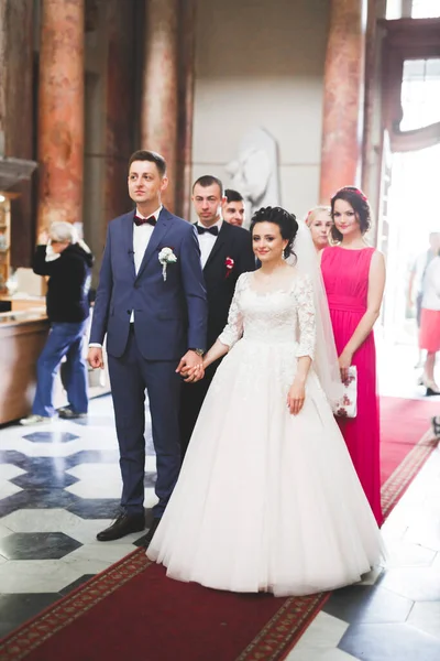 Bröllopspar bida och brudgum gifta sig i en kyrka — Stockfoto
