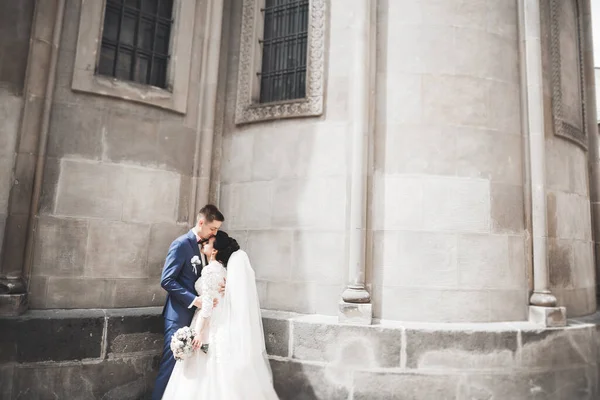 아름다운 도시에서 긴 흰색 드레스를 입은 아름다운 행복 한 부부 — 스톡 사진